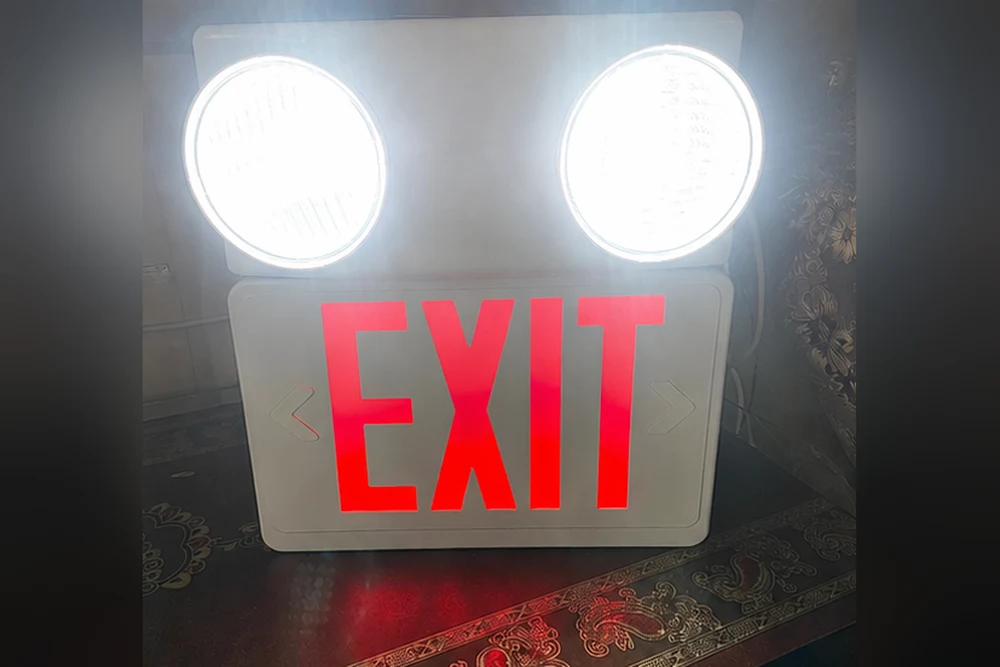 LED exit sign with battery-backed emergency light heads, illuminated, installed by HIFAZAT in Lahore